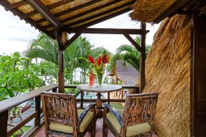 a patio with a table and chairs on a balcony at Bali Natha Beach Front in Canggu
