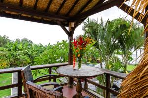 a table with a vase of flowers on a balcony at Bali Natha Beach Front in Canggu