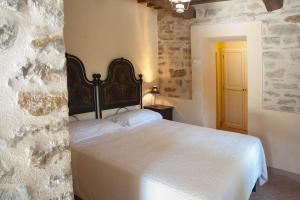 ein Schlafzimmer mit einem weißen Bett in einem Zimmer in der Unterkunft La Tavola Dei Cavalieri in Assisi