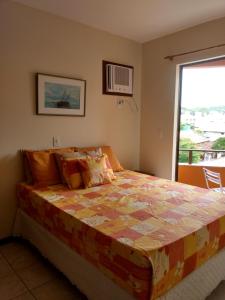 1 dormitorio con 1 cama grande y ventana en Residencial Com. Dória, en Bombinhas