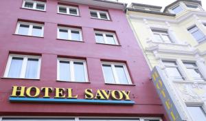 a hotelagency sign on the side of a pink building at Hotel Savoy Bonn in Bonn