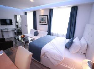 a bedroom with a large bed and a living room at Hotel Savoy Bonn in Bonn