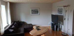 een woonkamer met een bank en een tafel bij Surf And Family Sauna And Spa in Hvide Sande