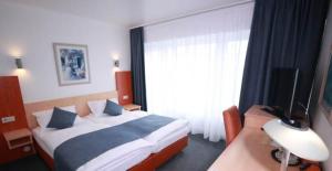 a hotel room with a bed and a window at Hotel Savoy Bonn in Bonn