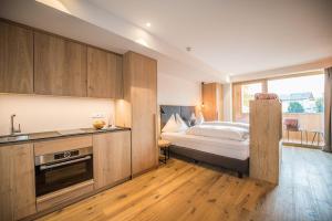 1 dormitorio con 1 cama y cocina con fregadero en Dining & Living Alpenrose, en Bresanona