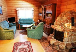 ein Wohnzimmer mit einem Kamin in einer Blockhütte in der Unterkunft Ferienhaus Hohenlubast in Gräfenhainichen