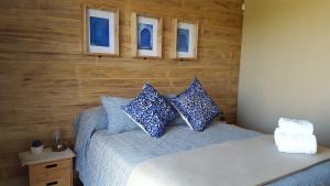 a bedroom with a bed with blue pillows on it at Radazul Apart de Mar & Campo in Chapadmalal