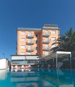 un hotel con piscina frente a un edificio en Hotel Bixio, en Lido di Camaiore