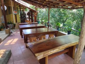 un grupo de mesas y sillas de madera en un patio en El Eden Bungalows, en Mazunte