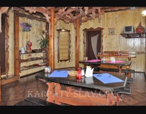a room with wooden walls and a table and chairs at "Різьб'ярська садиба" in Slavske