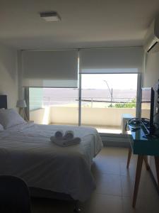 a bedroom with a bed and a large window at Dos Orillas Monoambiente 412 in Colonia del Sacramento