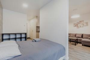 a white bedroom with a bed and a couch at Apartments Vilnius 1 near center with a roof terrace and parking in Vilnius