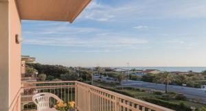 d'un balcon avec une chaise blanche et une vue sur l'océan. dans l'établissement Hotel Bixio, à Lido di Camaiore