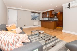 a living room with a couch and a glass table at One bedroom Hyde Park Apartment in London