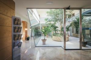 a large glass door in a building with potted plants at Hotel Costa Azul in Balestrate