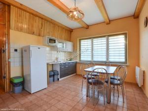 a kitchen with a table and chairs and a refrigerator at Apartamenty Rownia in Ustrzyki Dolne