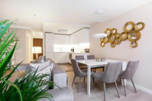 una sala da pranzo e un soggiorno con tavolo e sedie. di Luxury for everyone - Hills Park Lux Apartments 1 a Vilnius
