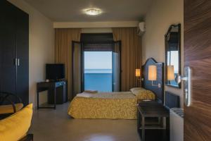 a hotel room with a bed and a television at Hotel Costa Azul in Balestrate