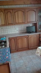 una cucina con armadi in legno e pavimento piastrellato di Appartamento lerpino a Sappada