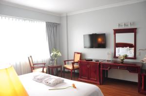 Habitación de hotel con cama, escritorio y espejo. en Kingdom Hotel, en Lima