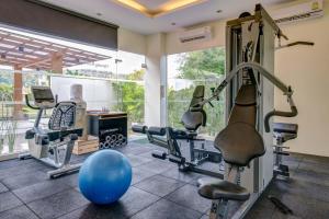 un gimnasio con equipamiento de ejercicio y una bola azul en una habitación en Sunset Bliss, en Klong Muang Beach