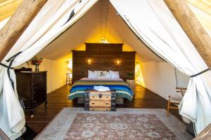 a bedroom with a bed and a canopy at Conestoga Ranch Glamping Resort in Garden City