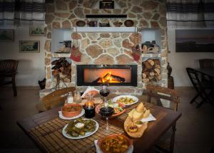 a table with food and wine glasses and a fireplace at Limeri Traditional Guest House in Monólithos