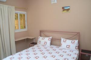 a bedroom with a bed with pillows and a window at Hotel La Perle in Saint-Louis