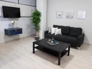 Sala de estar con sofá negro y mesa de centro en NUEVOS DEPARTAMENTOS CENTRO HISTÓRICO A 200 MTS DEL MALECÓN, en La Paz