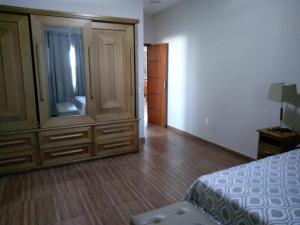 a bedroom with a dresser and a bed and a cabinet at Frente a Praia. Ótima casa barra de são João Rio das ostras,fino acabamento in Barra de São João