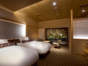 a hotel room with two beds and a window at Saka Hotel Kyoto in Kyoto