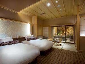 a hotel room with two beds and a window at Saka Hotel Kyoto in Kyoto