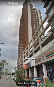 un edificio alto con una motocicleta delante en 21C Riviera Up Condominium en Pak Kret