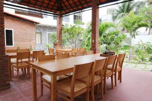uma sala de jantar com uma mesa de madeira e cadeiras em My Ca Hotel em Cam Ranh