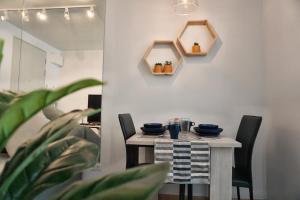 a dining room table with two chairs and a mirror at The Kith Plus Sukhumvit 113 by BLK in Bangna