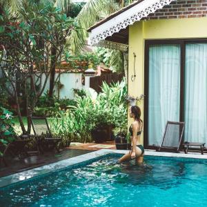 a woman in a bikini standing in a swimming pool at Casugria Dutch Residence 1810 in Malacca