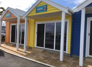 un edificio amarillo y azul con un cartel en él en Port Lincoln Shark Apartment 1, en Port Lincoln