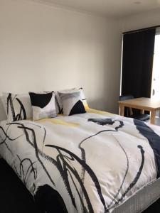 a bed with a black and white blanket on it at Port Lincoln Shark Apartment 1 in Port Lincoln