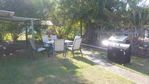 a table and chairs and a grill in a yard at Sailors Rest in Brisbane