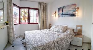 a white bedroom with a bed and two windows at Sol y Relax, Lubina Sol in Mijas Costa +29 photos