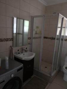 uma casa de banho com um chuveiro, um lavatório e um WC. em 84 Camarque Umdloti beach em Umdloti