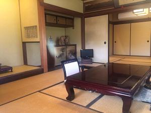 a living room with a table and a television at Ise Todaya Ryoan in Ise
