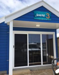 a small blue building with a sign on it at Port Lincoln Shark Apartment 3 in Port Lincoln