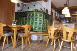 a dining room with wooden chairs and a green cabinet at Gasthaus zum Stausee in Grafenau