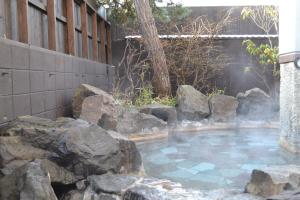 函館市にある湯の川温泉 笑 函館屋の岩の入った庭園の温泉