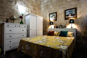 a bedroom with a bed and a dresser at Cosy Townhouse in Historic Centre in Birgu