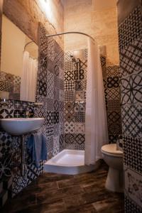 a bathroom with a shower and a sink and a toilet at Cosy Townhouse in Historic Centre in Birgu