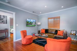 uma sala de estar com cadeiras laranja e um sofá em Stylish 2 Bed & 2 Bath at the Heart of Hollywood with Free Parking - One Car only em Los Angeles