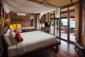 ein Schlafzimmer mit großem Bett und Balkon in der Unterkunft Serendipity Beach Resort Koh Lipe in Ko Lipe
