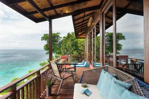 a balcony with a table and chairs and the ocean at Serendipity Beach Resort Koh Lipe in Ko Lipe